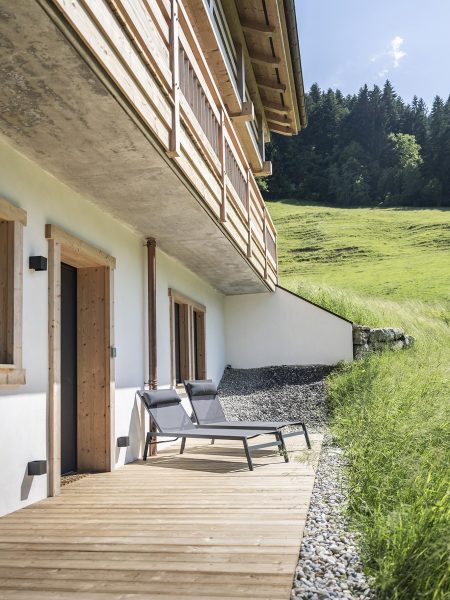 Terrasse en bois et transats à l'extérieur du chalet Zenspace en été